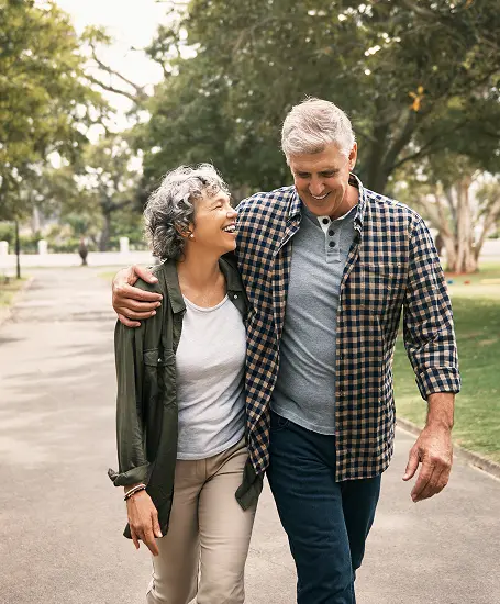 couple walking down a street with the man wrapping his arm over the woman's shoulder